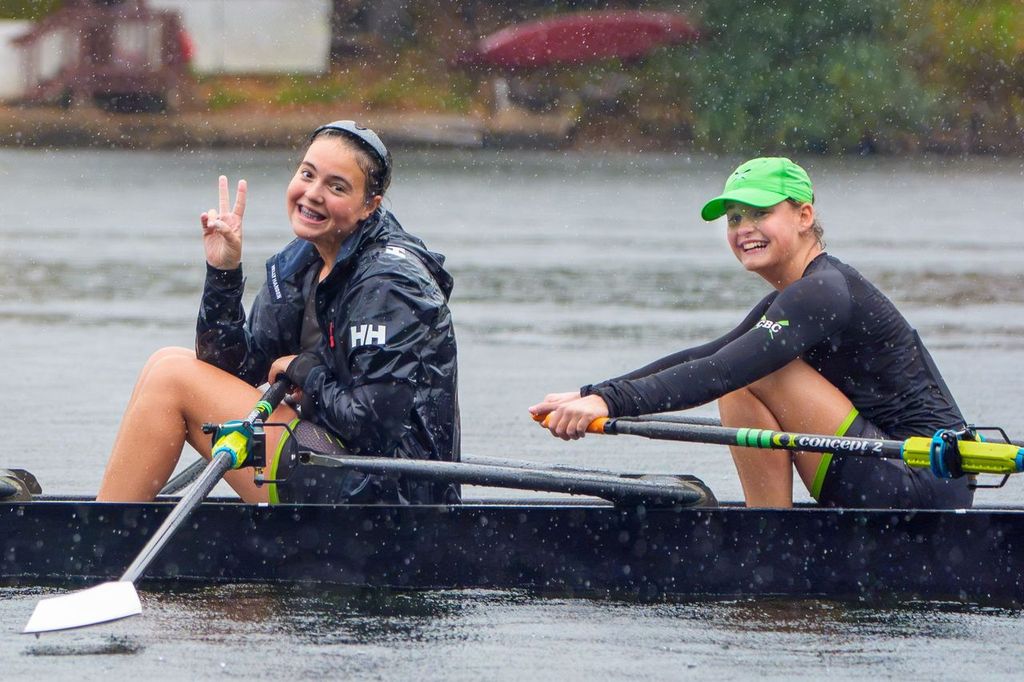 Two CBC rowers smiling in their boat in the rain at the Head of the Housatonic